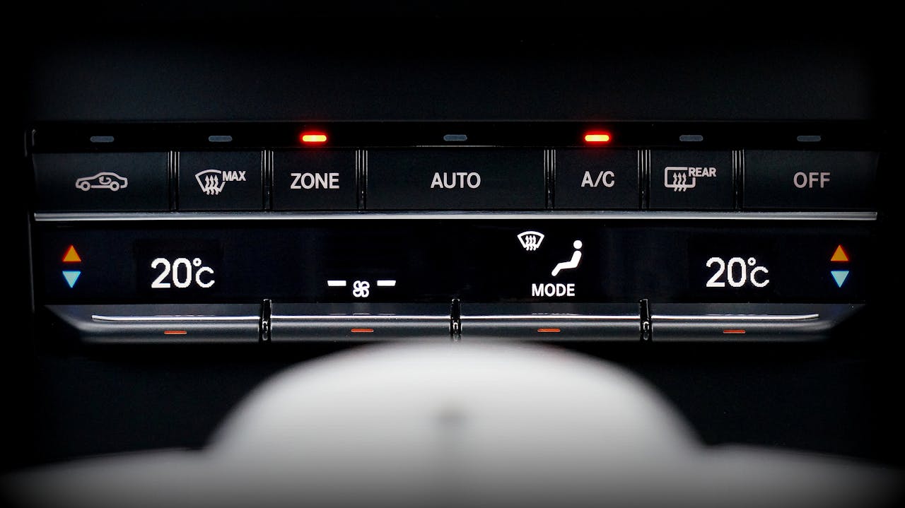 about-03 Close-up image of a car's climate control panel with digital temperature display.