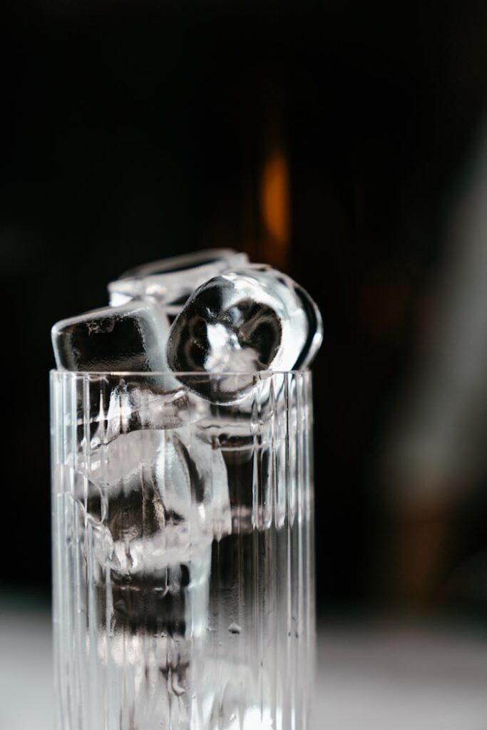pexels photo 4667193 Close-up of clear ice cubes stacked in a glass with a dark background, symbolizing refreshment.